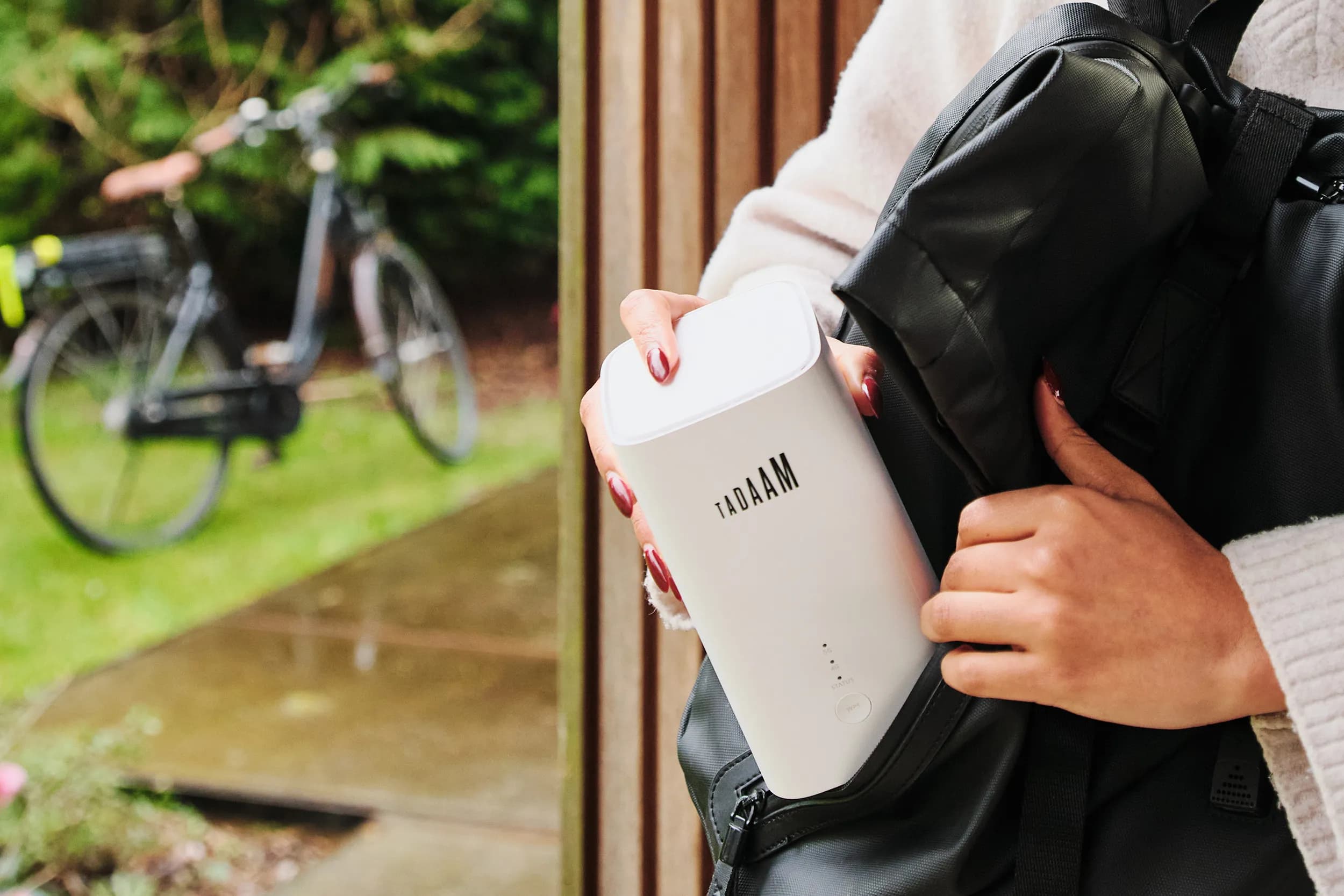 An image of a man walking through the door with a bag and a TADAAM modem sticking out of the bag.
