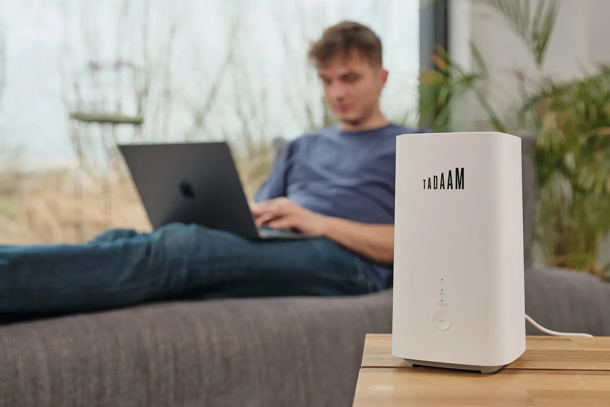 The TADAAM modem with in the background a person working on a laptop